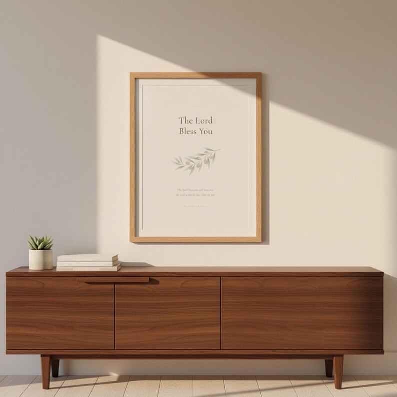 The Lord Bless You Numbers 6 24 26 Nursery Bible Verse Print Christian Wall Art, in gentle sage green nursery design with soft botanical watercolor illustration and calming earth tones, displayed in a bright modern entryway next to a coat rack with natural greenery, serving as welcoming faith-filled home decor