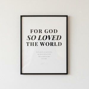 John 3 16 Wall Art For God So Loved the World Scripture Print Modern Christian, — "For God so loved the world that He gave His one and only Son", in contemporary bold serif typography in black on clean white background, photographed in beautiful close-up detail showing the premium glass frame reflection, the crisp typography and the intricate artistic details of the design