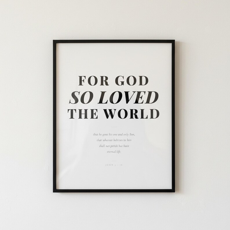 John 3 16 Wall Art For God So Loved the World Scripture Print Modern Christian, — "For God so loved the world that He gave His one and only Son", in contemporary bold serif typography in black on clean white background, photographed in beautiful close-up detail showing the premium glass frame reflection, the crisp typography and the intricate artistic details of the design