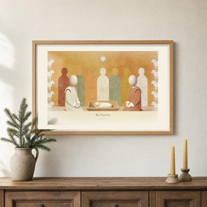 Room mockup of The Nativity from the Christmas story set, framed in light oak on a warm neutral wall. The artwork shows the wrapped child in a low manger between two kneeling figures beneath a single star, with sheep along both edges. Wide cream mat and restrained fresco palette suit a calm living room or advent display.