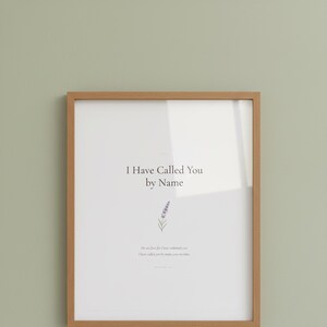 Isaiah 43 1 I Have Called You by Name framed scripture print in oak frame with glass reflection hung on sage green wall. Close-up hero product shot showing watercolor lavender sprig illustration and Bible verse. Christian nursery printable digital download for baptism gift.
