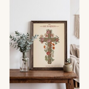 William Morris He is Risen Cross Print – Floral Easter Christian Decor, — "He is not here; He has risen, just as He said", in vintage William Morris Arts and Crafts botanical style with ornate floral border on aged cream parchment, showcased in an elegant contemporary home interior with curated decor elements, demonstrating how this Christian art piece elevates any living space
