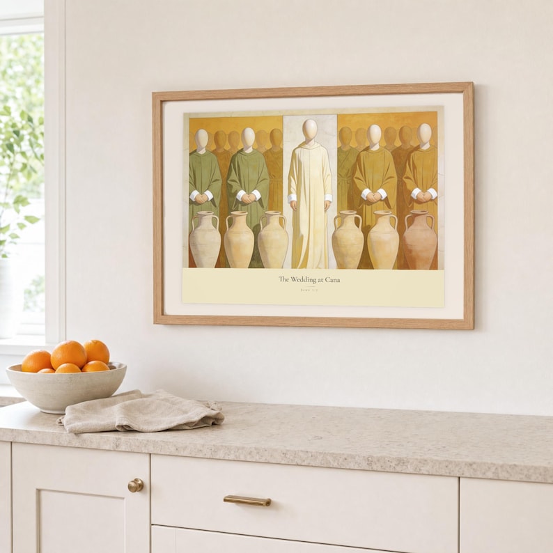 Kitchen mockup of The Wedding at Cana framed in light oak above a pale stone counter, white cabinetry, a linen cloth, and a bowl of oranges. The artwork shows Christ centered between six complete stone jars, with three on the left and three on the right. Bright window light and the warm cream mat demonstrate how the Christian print works in a clean, welcoming kitchen interior.
