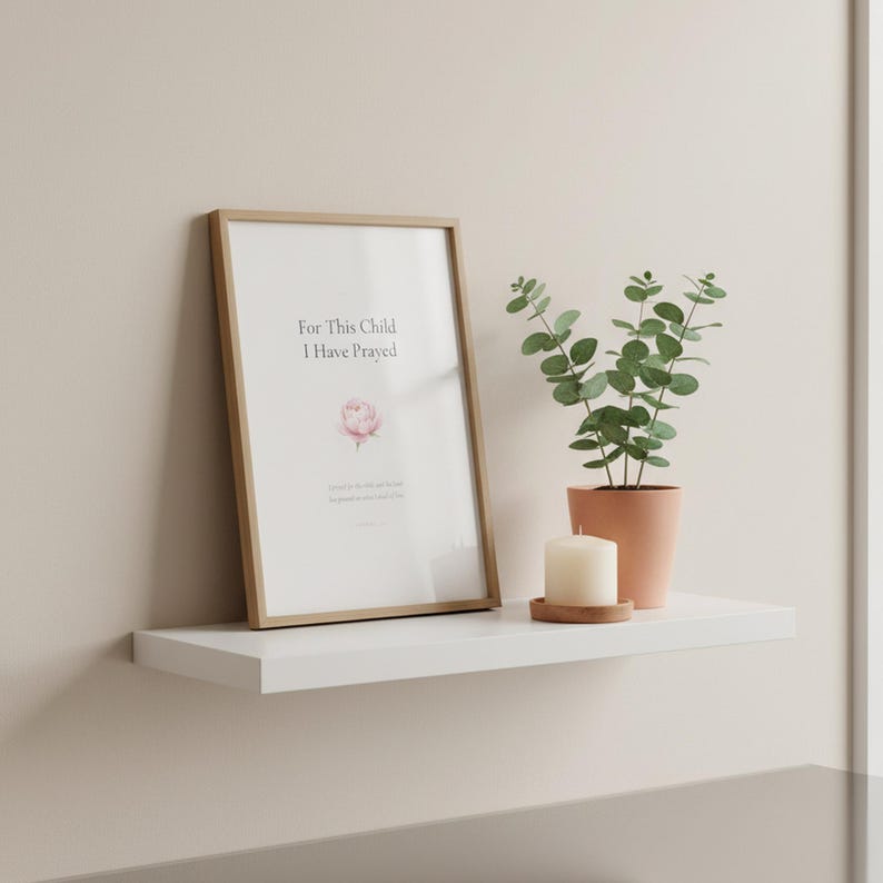 For This Child I Have Prayed 1 Samuel 1:27 nursery wall art print with a soft pink peony in minimalist typography. Framed in wood on a white floating shelf with eucalyptus and a candle. Christian nursery decor, baby shower or baby dedication gift for a new mom. Instant digital download printable.