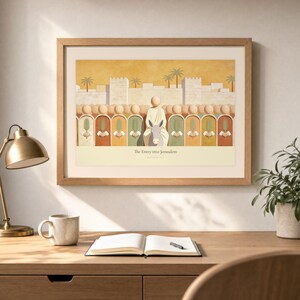 Desk mockup of The Entry into Jerusalem in a light oak frame above a wooden workspace with a brass lamp, ceramic mug, open notebook, pen, and leafy plant. The artwork shows the entry into Jerusalem, with a crowd of faceless figures raising flat palm fronds along the city wall. Angled sunlight, neutral styling, and cream matting place the Bible story print in a quiet study or home office setting.