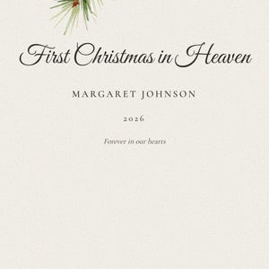 Detailed close up of the personalized name and year beneath the snowy cardinal illustration. Crisp lettering shows Margaret Johnson and 2026 below First Christmas in Heaven, while individual pine needles, soft snow and painted red feather details remain visible nearby. Fine paper grain and careful typography highlight the custom finish of this Christmas remembrance gift.
