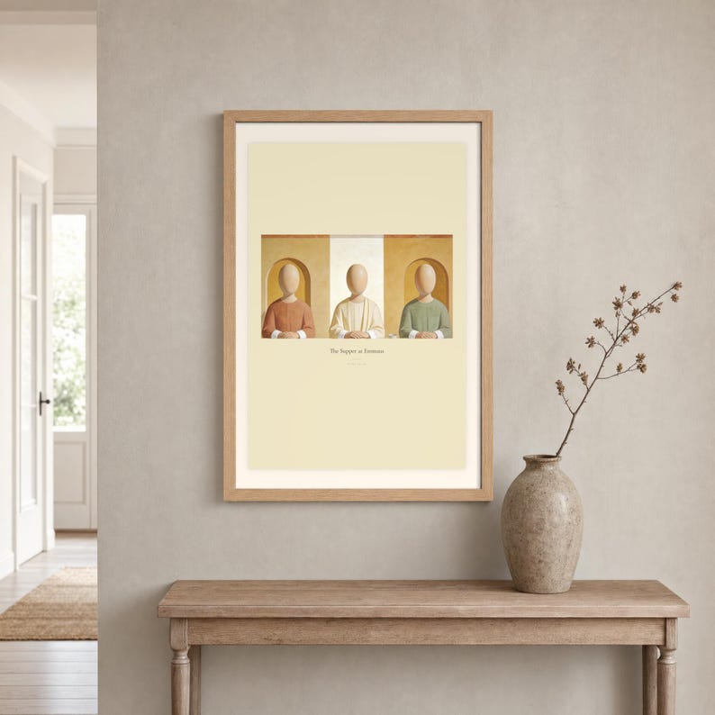 Room mockup of The Supper at Emmaus displayed in a light oak frame on a warm neutral wall. The landscape artwork shows Christ seated at the center of a supper table within warm rounded niches. A wide cream mat and restrained fresco palette suit a calm living room, prayer space, or Christian home. The printed title and Luke 24:30 remain visible beneath the image.