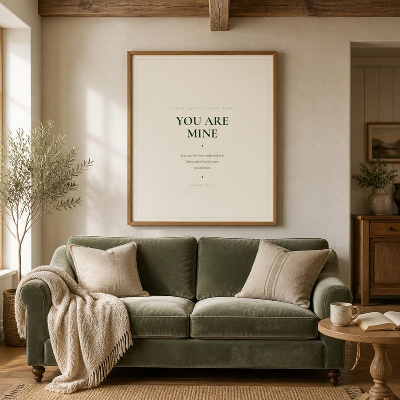You Are Mine Isaiah 43:1 scripture print minimalist christian baptism gift baby dedication nursery wall art dark forest green typography on warm cream background, above sage grey linen sofa bright airy living room natural window light room lifestyle scene, digital download printable wall art instant download