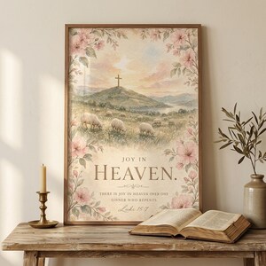 Joy in Heaven Luke 15:7 watercolor cross christian wall art leaning on a rustic console table beside an open vintage Bible, brass candlestick, and dried olive branch. Reverent Christian home decor — pastor appreciation, faith digital art, scripture home decor gift. Digital download.