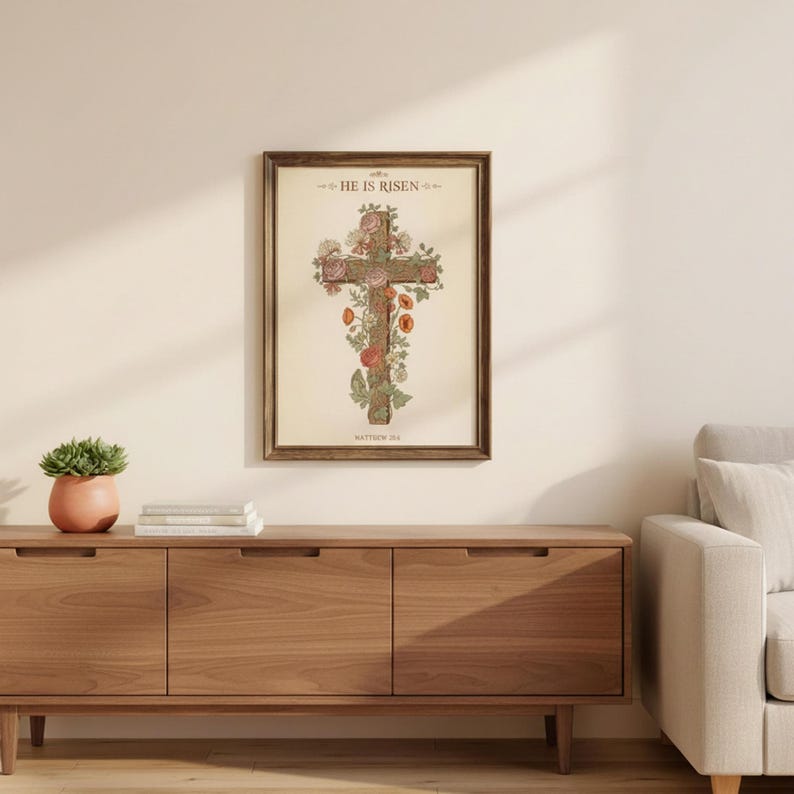 William Morris He is Risen Cross Print – Floral Easter Christian Decor, in vintage William Morris Arts and Crafts botanical style with ornate floral border on aged cream parchment, displayed in a bright modern entryway next to a coat rack with natural greenery, serving as welcoming faith-filled home decor