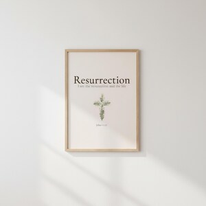 He is Risen Easter Wall Art, Floral Cross Scripture Print, — "He is not here; He has risen, just as He said", in beautiful floral cross composed of spring roses, greenery and wildflowers, photographed in beautiful close-up detail showing the premium glass frame reflection, the crisp typography and the intricate artistic details of the design
