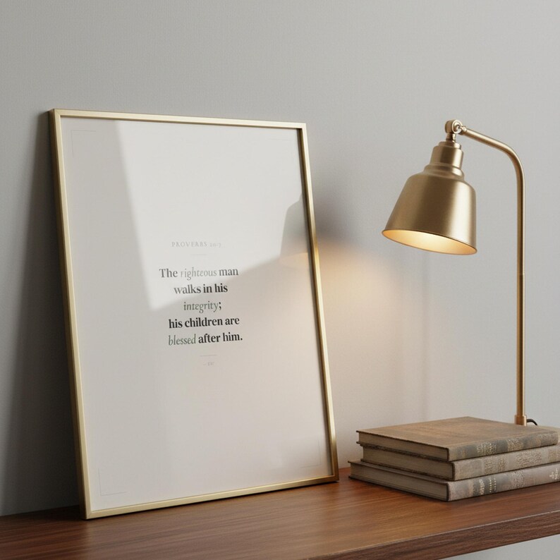 Proverbs 20:7 bible verse wall art The righteous man walks in his integrity his children are blessed after him ESV in elegant gold glass frame on dark walnut shelf with brass desk lamp and vintage books. Sage green Father Day scripture print for Christian dad pastor appreciation gift. Digital download printable wall art for home office study bedroom living room decor from TheFramedVerse