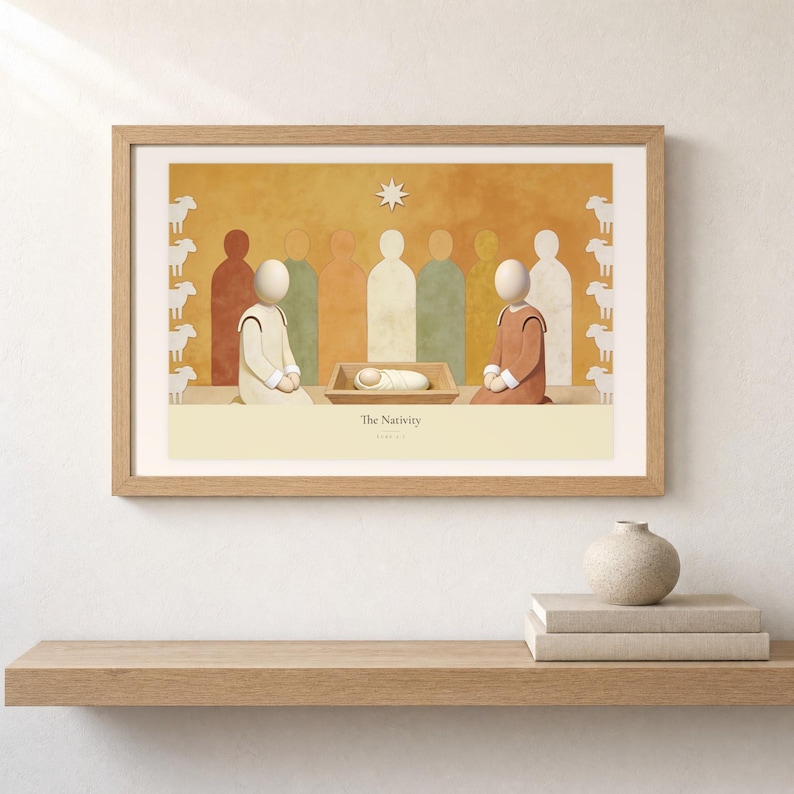 Shelf mockup of The Nativity in a light oak frame resting on a pale wood surface beside stacked neutral books and a rounded ceramic vase. The framed print shows the wrapped child in a low manger between two kneeling figures, beneath a single star. Cream matting, soft wall texture, and natural light present the horizontal Bible artwork at an easy domestic scale.
