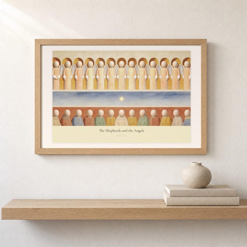 Shelf mockup of The Shepherds and the Angels in a light oak frame resting on a pale wood surface beside stacked neutral books and a rounded ceramic vase. The framed print shows a row of angels above shepherds and their sheep, with a star set between the two groups. Cream matting, soft wall texture, and natural light present the horizontal Bible artwork at an easy domestic scale.