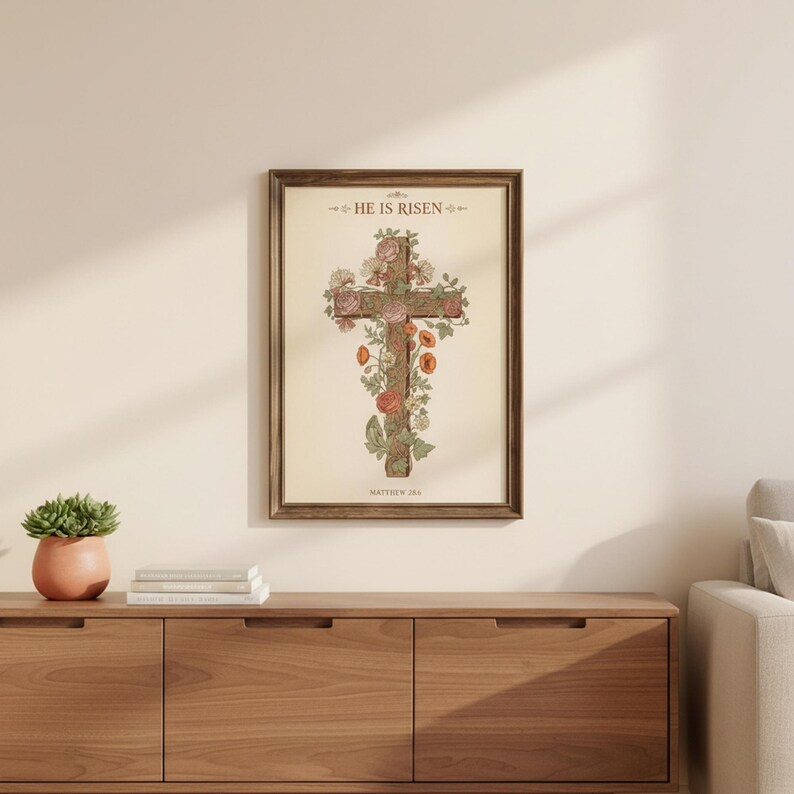 William Morris He is Risen Cross Print – Floral Easter Christian Decor, — "He is not here; He has risen, just as He said", in vintage William Morris Arts and Crafts botanical style with ornate floral border on aged cream parchment, photographed in beautiful close-up detail showing the premium glass frame reflection, the crisp typography and the intricate artistic details of the design
