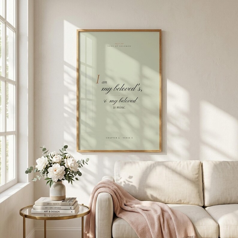 Song of Solomon 6:3 'I Am My Beloved's' coquette sage Christian wedding wall art print framed in light oak above a velvet sage sofa with cream knit throw, gold candlestick on side table, soft afternoon light, romantic feminine farmhouse Christian newlywed decor, instant digital download from TheFramedVerse on Etsy