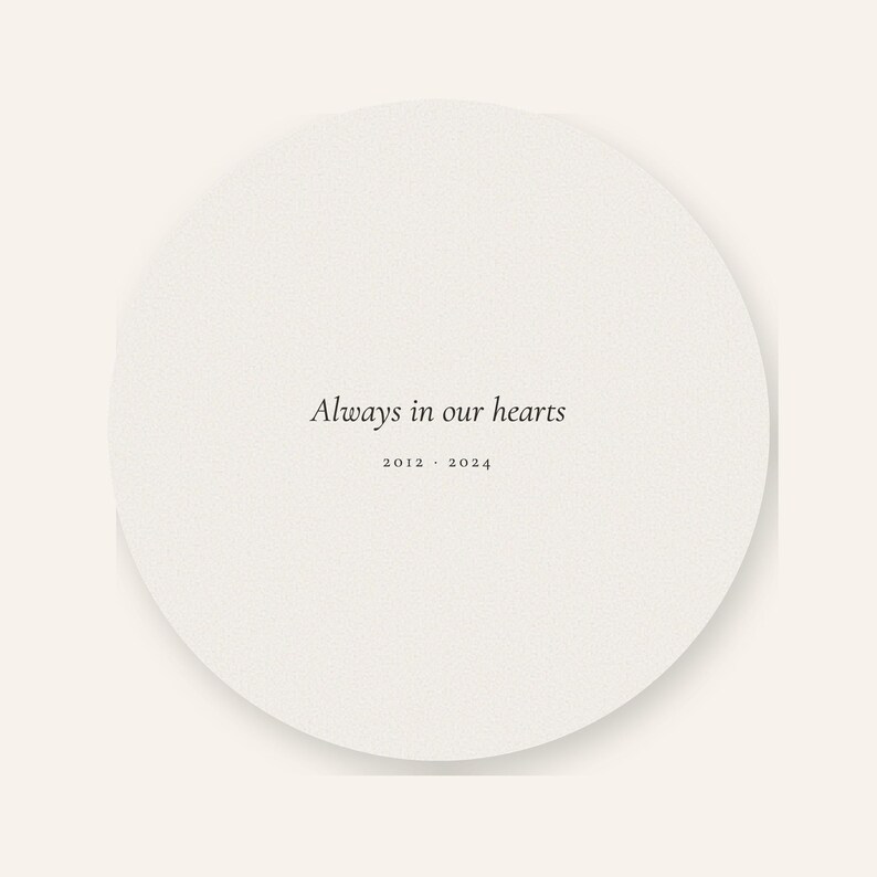 Clean back artwork view of the personalized acrylic pet memorial ornament, showing the words Always in our hearts centered on the round keepsake. Soft watercolor details coordinate with the front while the ribbon opening and smooth circular edge remain visible. The plain background clearly presents the double sided printing included with this physical remembrance ornament.