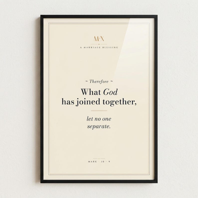 Mark 10:9 'What God Has Joined Together' modern Christian wedding scripture print in thin black metal frame, frontal view on off-white textured wall, modern minimalist styling with soft top light and gentle shadow below frame, e-commerce hero photograph, instant download from TheFramedVerse