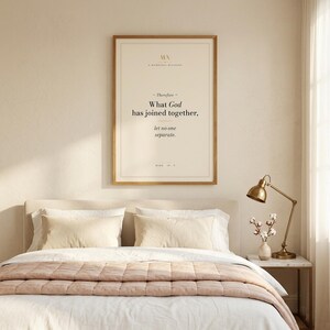 Mark 10:9 modern Christian wedding wall art print framed in oak above a cream velvet sofa with linen throw and ivory pillows, side table with ceramic mug and open Bible, cottage farmhouse Christian newlywed living room, soft afternoon light, digital download from TheFramedVerse Etsy