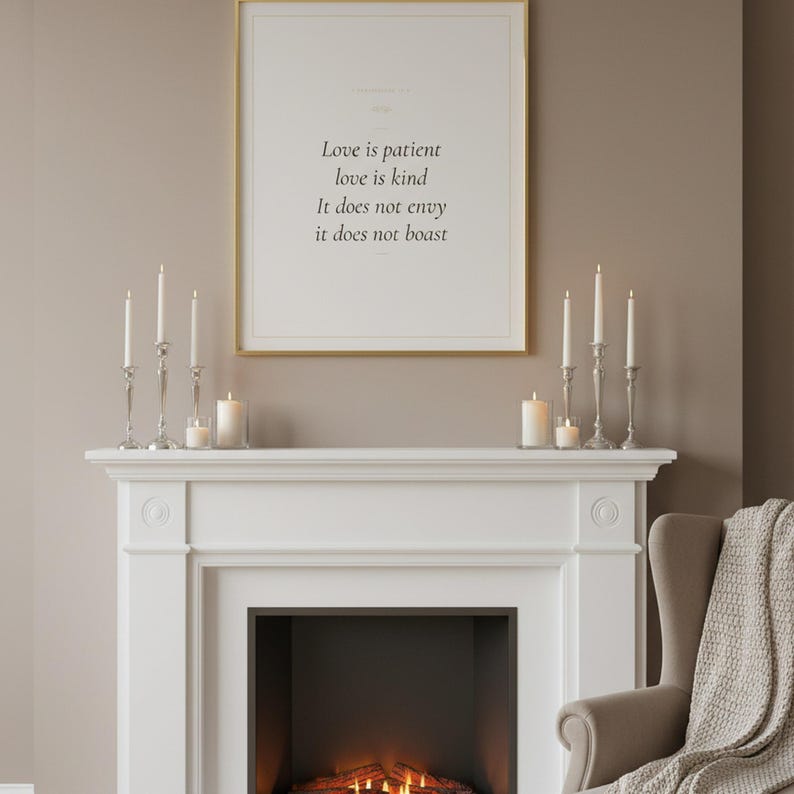 Love Is Patient Love Is Kind 1 Corinthians 13:4 Wall Art Christian Wedding, in romantic wedding typography with elegant calligraphy, delicate gold ornamental accents on warm blush background, styled on a wooden floating shelf next to a ceramic vase with dried eucalyptus branches and stacked books, creating a warm and inviting Christian home decor vignette
