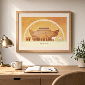Desk mockup of Noah and the Ark in a light oak frame above a wooden workspace with a brass lamp, ceramic mug, open notebook, pen, and leafy plant. The artwork shows a wooden ark beneath a rainbow with three animal pairs, elephants, giraffes, and sheep. Angled sunlight, neutral styling, and cream matting place the Bible story print in a quiet study or home office setting.