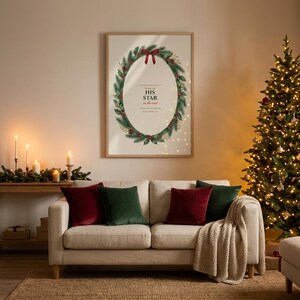 Matthew 2:2 His Star nativity scripture print from the Christmas Story set, slim oak frame behind glass on a warm Christmas living room wall above a cream sofa with red and green velvet cushions, glowing Christmas tree and candles, festive evening light. Printable Christian Christmas wall art digital download by TheFramedVerse.