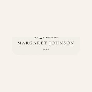 Close up of the personalized name and year zone on the First Christmas in Heaven ornament. The detailed crop highlights MARGARET JOHNSON in spaced serif lettering with 2026 centered below on the softly textured cream design. This view helps buyers see the readable custom details and careful finish of the cardinal memorial keepsake before ordering.