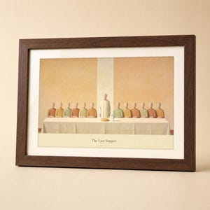 The Last Supper modern Christian print in a solid walnut landscape frame, shown frontally on a neutral cream studio backdrop with a soft top left key light and a faint glass reflection. Thirteen flat abstract figures gather around a long table with bread and a chalice, the LUKE 22:19 reference set in small caps below. Terracotta and olive earth tone digital download from TheFramedVerse.
