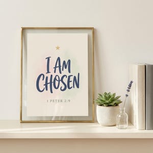 I Am Chosen 1 Peter 2:9 bible verse print in glass frame on cream shelf with green succulent, dried lavender, and stacked books. Modern hand-lettered Christian affirmation. Shows versatile styling of Kids Christian wall art set of 6 — great housewarming gift, baptism gift, sunday school decor for modern Christian homes.