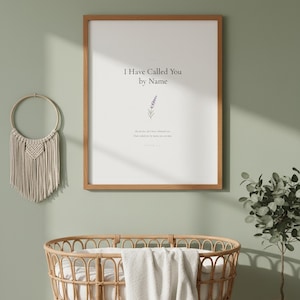Isaiah 43 1 I Have Called You by Name framed wall art on sage green wall above rattan bassinet with white linens. Macrame decor and eucalyptus. Watercolor lavender sprig illustration. Christian nursery printable digital download for baby shower baptism gift.