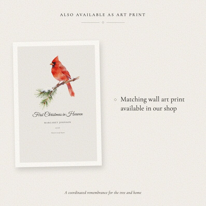 Cross sell graphic showing the matching First Christmas in Heaven wall art print beside a note that it is also available in the shop. The vertical art print carries the same snow covered pine branch, red cardinal, Margaret Johnson and 2026 design as the personalized ornament, offering a coordinated remembrance display for a mantel, shelf or memorial space.