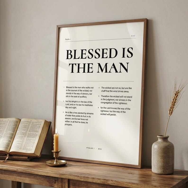 Psalm 1 'Blessed Is The Man' framed print leaning on a rustic wooden console next to an open vintage leather Bible, brass candlestick with lit beeswax candle, and stoneware vase with dried wheat. Reverent Christian masculine home decor, Father's Day gift, printable from TheFramedVerse on Etsy.
