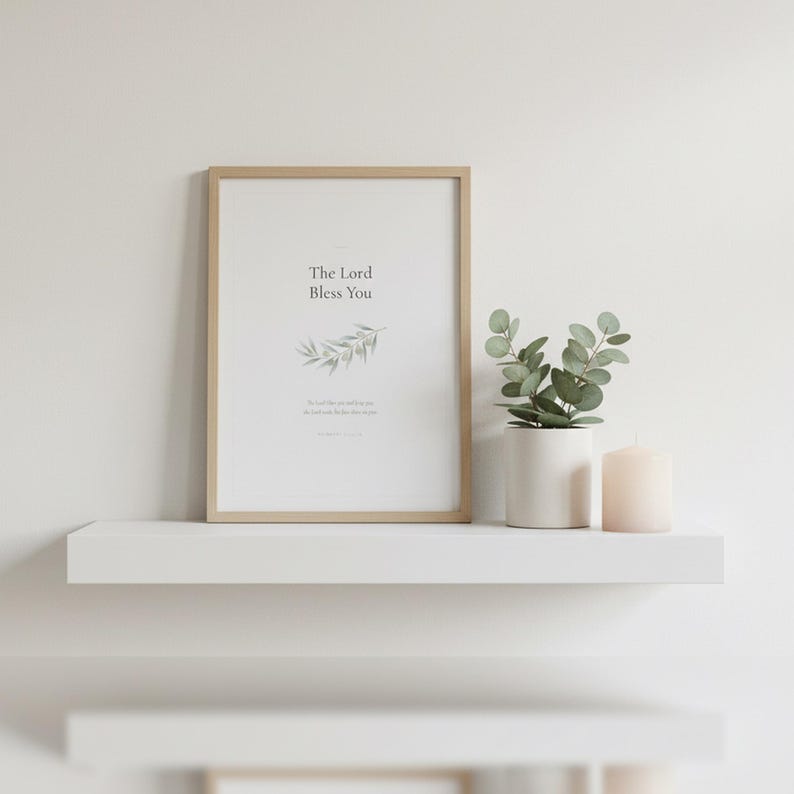 The Lord Bless You Numbers 6 24 26 Nursery Bible Verse Print Christian Wall Art, — "The Lord bless you and keep you; the Lord make His face shine on you", in gentle sage green nursery design with soft botanical watercolor illustration and calming earth tones, photographed in beautiful close-up detail showing the premium glass frame reflection, the crisp typography and the intricate artistic