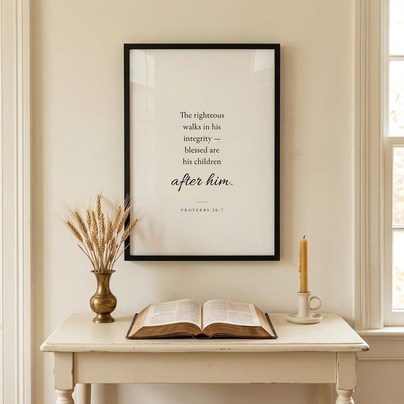Proverbs 20:7 'The Righteous Walks in Integrity' Christian scripture print in matte black frame above a cream console table with open family Bible in a classic Christian family home entryway. Christian wall art for living room or entryway, Father's Day gift for dads, instant digital download.