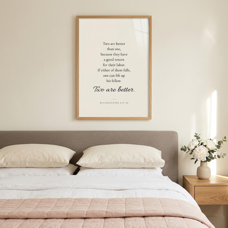 Ecclesiastes 4:9-10 'Two Are Better Than One' wedding scripture print in oak frame above the headboard of a newlywed bedroom with white linen, blush throw, and white peonies. Christian wedding wall art for bedroom, newlywed gift, first anniversary, engagement present, instant digital download.
