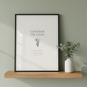 Consider the Lilies Matthew 6 sage green botanical wall art print leaning on white shelf beside terracotta vase with dried eucalyptus and cream linen book, warm morning light, floral scripture minimalist christian home decor, digital download TheFramedVerse Etsy, housewarming baptism gift