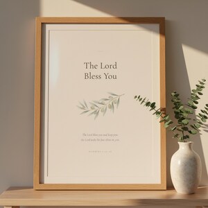 The Lord Bless You Numbers 6 24 26 Nursery Bible Verse Print Christian Wall Art, — "The Lord bless you and keep you; the Lord make His face shine on you", in gentle sage green nursery design with soft botanical watercolor illustration and calming earth tones, showcased in an elegant contemporary home interior with curated decor elements, demonstrating how this Christian art piece elevates any