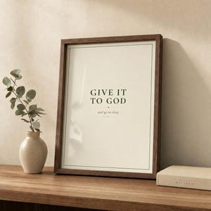Give It To God print in walnut frame on wooden shelf with ceramic vase and eucalyptus. Cozy bedroom scripture decor. Christian download from TheFramedVerse.