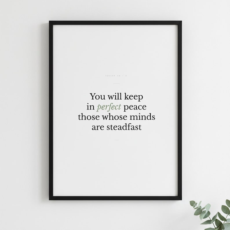 Isaiah 26:3 Wall Art You Will Keep in Perfect Peace Minimalist Scripture Print B — lifestyle mockup in modern room setting with elegant framed print on wall. This modern minimalist christian scripture wall art print features beautiful serif typography on warm cream background. Isaiah 26:3 bible verse digital download printable for home office bedroom living room gallery wall decor. Perfect chri...