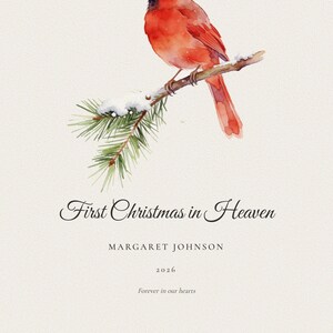 Clean front view of the First Christmas in Heaven master print on a soft winter neutral background without a frame or room props. A red cardinal rests among snow dusted pine branches above the personalized name Margaret Johnson and year 2026. The uncluttered image shows the complete seasonal memorial composition, crisp typography, botanical detail and subtle paper texture.