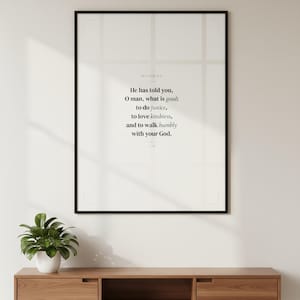 Micah 6:8 bible verse wall art hanging in thin black glass frame on warm white living room wall above mid-century modern console table with green plant. Natural daylight with window shadow. He has told you O man what is good to do justice to love kindness and to walk humbly with your God ESV. Sage green scripture print Christian Father Day gift dad husband digital download printable for gallery wall decor