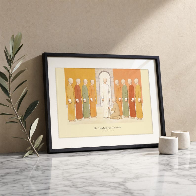 She Touched His Garment Matthew 9:20-22 print in a black wood frame on white marble, a single olive branch beside it and two lit stone candles, warm beige textured wall, bright natural morning light with a soft glass reflection, editorial still life Christian wall art digital download by TheFramedVerse