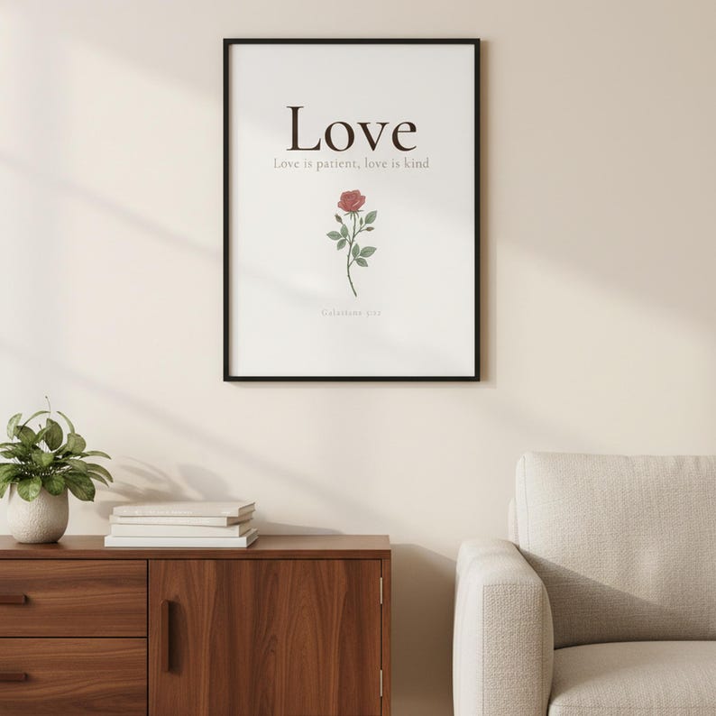 Love Fruit of the Spirit Christian wall art print featuring Galatians 5:22, with beautiful red rose botanical illustration, in minimalist botanical watercolor illustration on warm cream background with elegant serif typography, displayed in a beautifully styled modern living room above a warm wooden sideboard with soft natural light creating gentle shadows on the frame