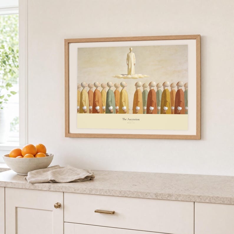 Kitchen mockup of The Ascension framed in light oak above a pale stone counter, white cabinetry, a linen cloth, and a bowl of oranges. The artwork shows Christ standing in light above a soft cloud while gathered witnesses look upward. Bright window light and the warm cream mat demonstrate how the Christian print works in a clean, welcoming kitchen interior.
