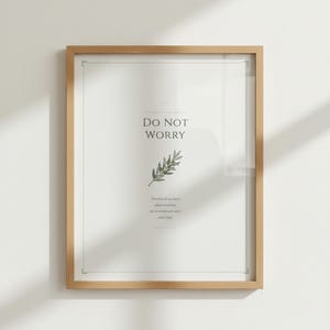 Do Not Worry Matthew 6:34 sage green scripture print in light wood frame, frontal white background product shot, crystal-clear serif typography on cream linen paper texture, elegant bible print botanical minimalist christian wall art, TheFramedVerse digital download, godly wall art baptism gift idea