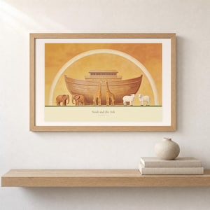 Shelf mockup of Noah and the Ark in a light oak frame resting on a pale wood surface beside stacked neutral books and a rounded ceramic vase. The framed print shows a wooden ark beneath a rainbow with three animal pairs, elephants, giraffes, and sheep. Cream matting, soft wall texture, and natural light present the horizontal Bible artwork at an easy domestic scale.