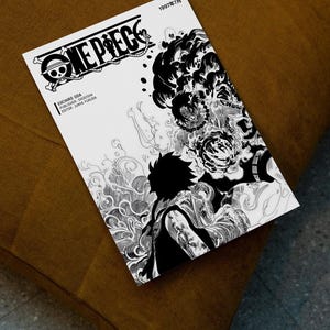May include: A black and white manga book titled "ONE PIECE" with a skull and crossbones logo. The cover features detailed illustrations of characters and swirling patterns. Text includes the date "1997年7月" and the names of the author, publisher, and editor.