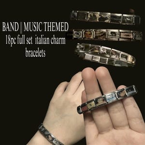 Puede incluir: Varios brazaletes italianos con imágenes temáticas de música. Un brazalete se lleva en la muñeca y otro se sostiene entre los dedos. El texto "BAND || MUSIC THEMED" es visible en la imagen.