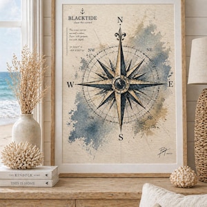 May include: Framed nautical art print featuring a compass rose design with the text "BLACKTIDE". The artwork has a vintage aesthetic with watercolor accents in blue and tan. The compass points to the cardinal directions.