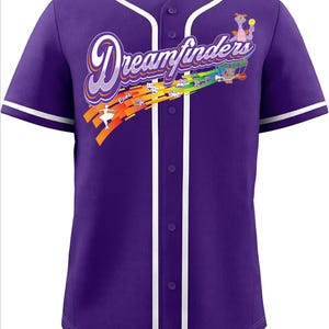 May include: Purple baseball jersey with white trim and buttons. The front of the jersey features a colourful graphic with the text "Dreamfinders" and a cartoon character holding a lightbulb.